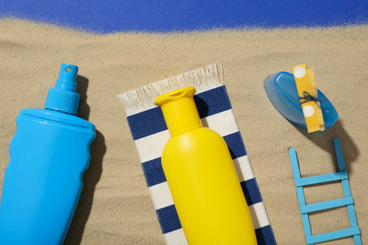A blue and yellow bottle of sunscreen, a towel and a ladder