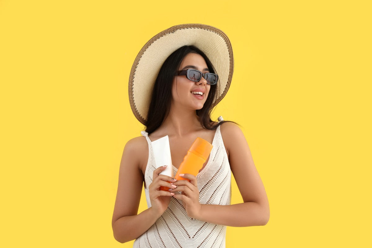 Beautiful young woman with sunscreen cream on yellow background